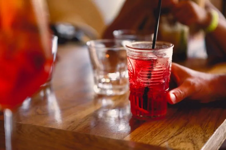 Unrecognizable,Person,Sitting,At,Table,And,Enjoying,Cool,Fruit,Cocktail